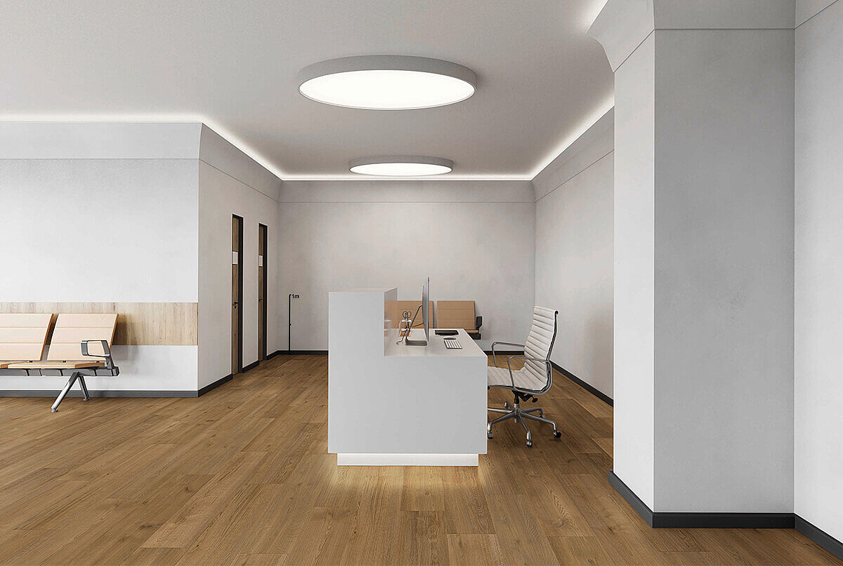 Moderner Empfangsbereich mit recyceltem Elastikboden in warmer Holzoptik.