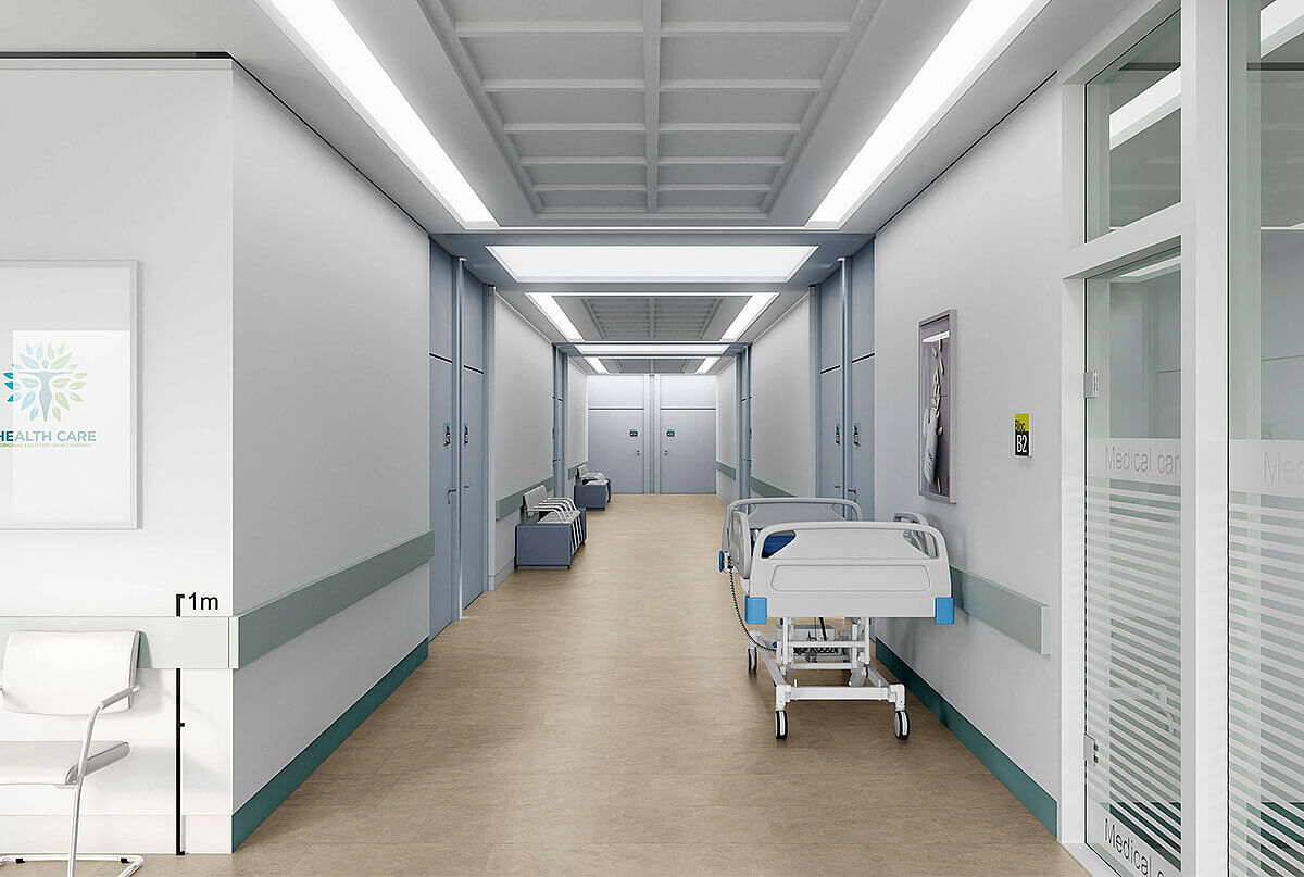 Krankenhausflur mit Bett und recyceltem Elastikboden in heller, mineralischer Optik.